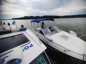 Policjanci podczas patrolu na wodzie kontrolują osoby pływające łodzie.