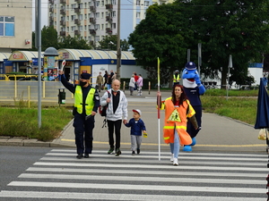 policjanci przechodzą z dzieckiem i jego opiekunem przez przejście dla pieszych