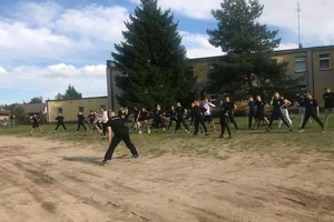 policjant prowadzi rozgrzewkę z uczniami klasy policyjnej