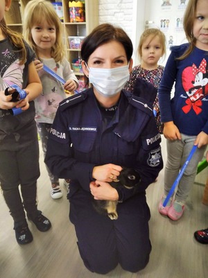 policjantka kuca i trzyma królika, obok stoją dzieci
